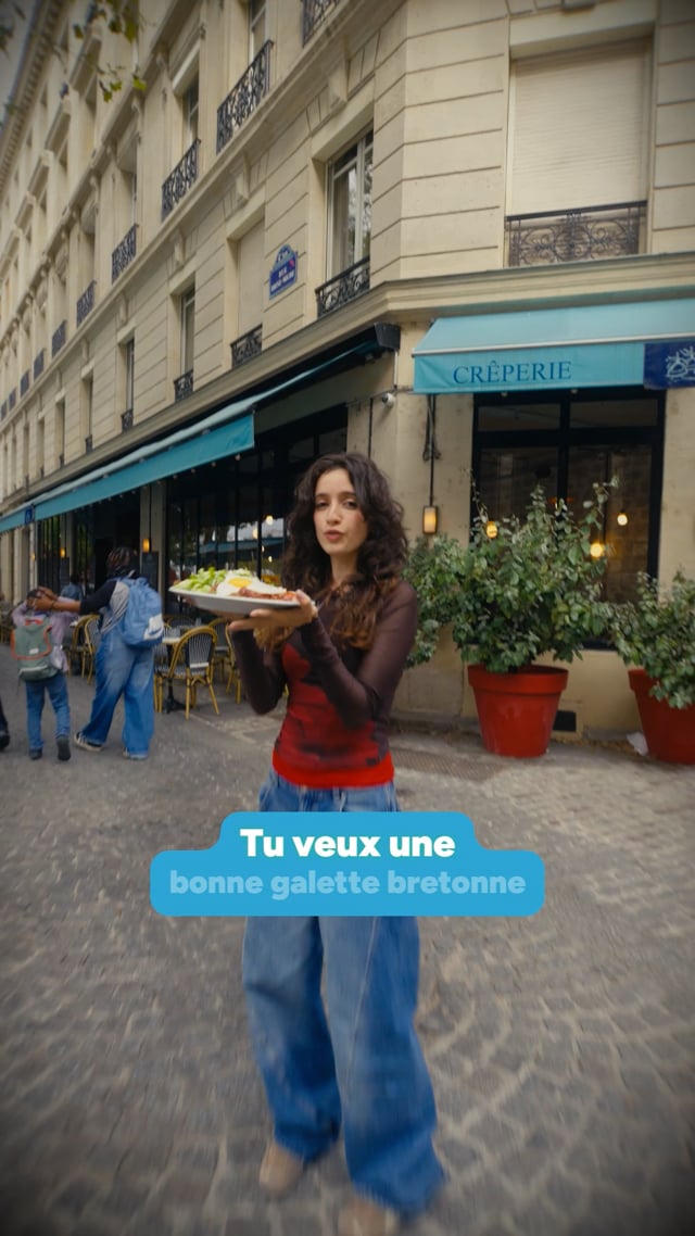 Une actrice présente une galette devant Crêperie Beaubourg